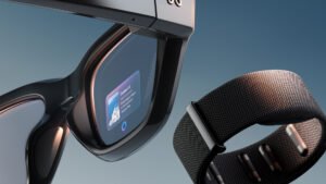 A close-up of smart glasses showing a small digital display in one lens, paired with a textured black wristband positioned beside the frame.